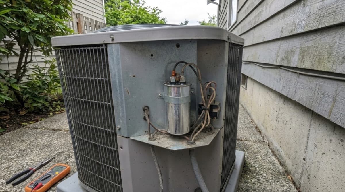 Burbank HVAC technician using a multimeter to diagnose a residential air conditioning condenser unit on a hot summer afternoon